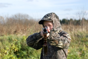 The girl in a camouflage aiming from a gun