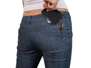 The female hand fills the pocket with a notebook of jeans