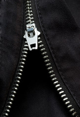A silver zipper on denim material