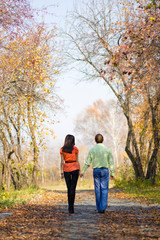 Young happy couple walking in the autumn park