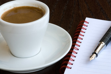 Cyprus coffe and  spiral notebook with a point pen.