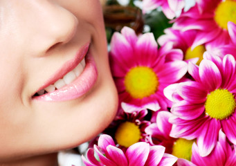 Obraz na płótnie Canvas girl healthy smile with pink chrysanthemum on a background