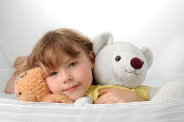 Young girl lying on the floor with two teddy bears. Smile face