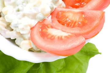 American salad and sliced tomatoes in a bowl isolated on white.