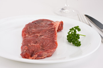 raw steak on a white plate