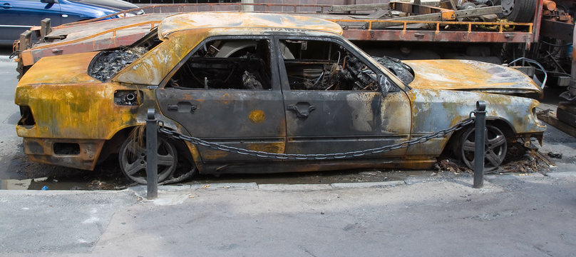 old destroyed car burned on the city street evacuation
