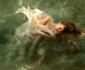 The beautiful girl sleeps in a sea cockleshell