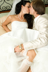 Obraz na płótnie Canvas Bride and groom kissing in the bedroom