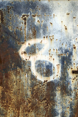 A faded number eight spray painted on rusted steel surface