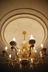 Large chandelier with candle shaped lights in a dark room