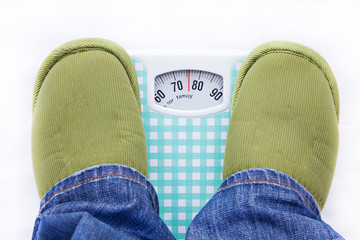 man feet on a bathroom scale showing weight