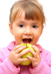 Lovely baby-girl eating green apple isolated over white