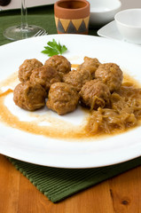 white platter with meat balls on onions sauce