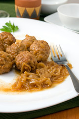white platter with meat balls on onions sauce