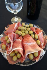 Spanish Serrano ham, olives and a bottle of red wine