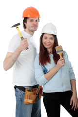 Young pair in a builder uniform with tools.