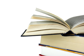 Opened book laying on other books isolated on white.