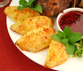 Scored crisp baked potatoes with paprika and mint sauce.
