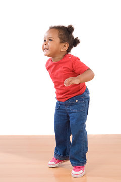 African Baby Girl On Tiptoe On A Over Wooden Floor