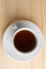 Cup with tea on wooden table.