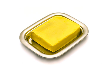 Butter on silver butter dish isolated on white background