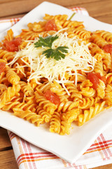 Cooked plate of fusilli pasta with tomato sauce. Shallow DOF