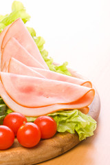 Fresh ham & salad on a wooden plate