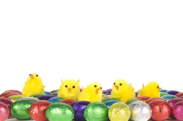 a group of colorful chocolate easter eggs and yellow chickens