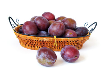 Basket of plums isolated on a white background