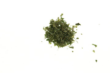 A small pile of dried chopped parsley leaves on white