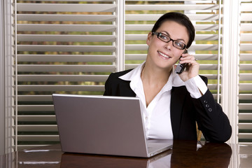 pretty business woman on the phone using laptop