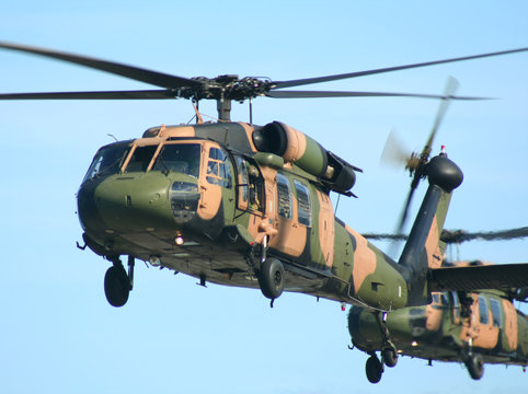 Two Army Blackhawk Choppers Fly In Close Formation.