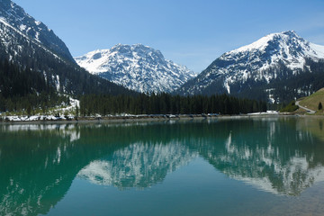 Fototapeta na wymiar Reflets de printemps sur le Stusee dans les Alpes Suisses