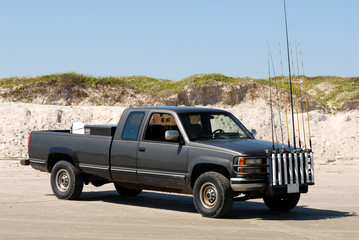Fishermans pickup truck with anglind rods on the beach - obrazy, fototapety, plakaty