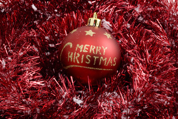 horizontal image of red merry christmas ball on red garland
