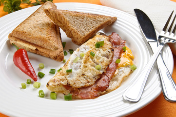 Breakfast - toasts, egg, bacon and vegetables