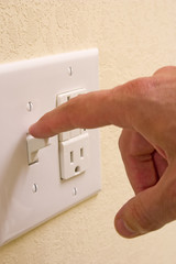 closeup of hand turning off light switch