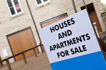 Estate agent for sale sign in front of new house