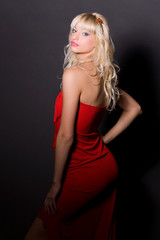Fototapeta premium Attractive girl in red dress, isolated on black background