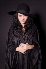 Beautiful girl in black hat, studio isolated