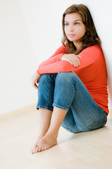 Fototapeta premium A lifestyle shot of a young woman sitting down on the floor
