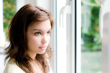 An attractive young woman staring out the window