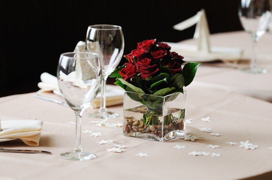 dark red rose arrangement on dinner table