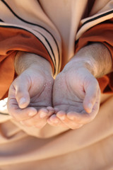 Beggar son with cupped hands together in hope for charity