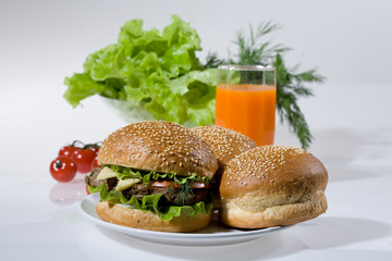 Hamburgers, greenery, tomatoes and juice