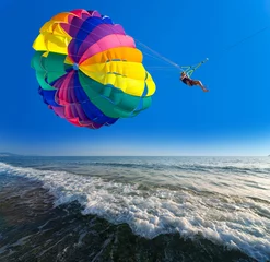 Gordijnen Man is parasailing in the blue sky © Guy Shapira