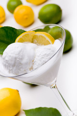 Zitronensorbet vor ganzen grünen und gelben Früchten
