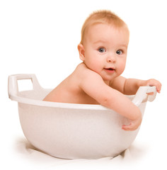 Cute baby having bath in white tub