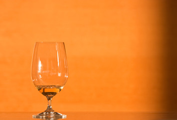 Glass of white wine on a modern countertop lit by evening light