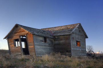 Obraz premium Old abandoned leaning farmhouse on Colorado prairie